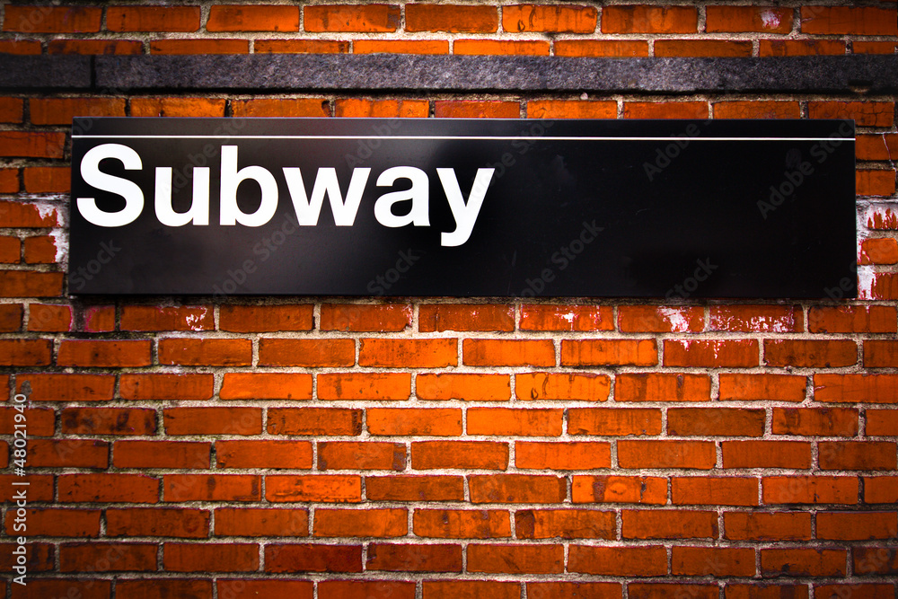 Fototapeta premium New York City subway sign entrance on brick wall
