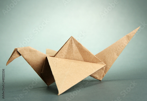 Origami crane on grey background