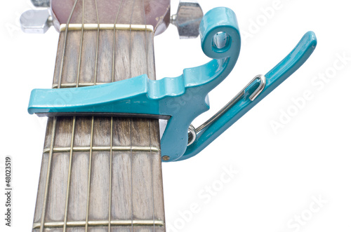 light sea green string capo with guitar on white background photo