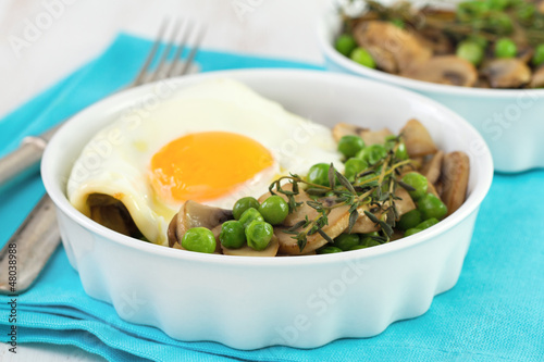 egg with green peas and mushrooms in white bowl