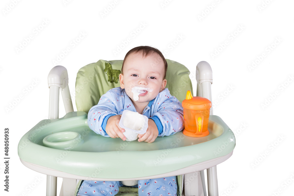 child is eating sitting at table, isolated over white child is eating sitting at table, isolated over white