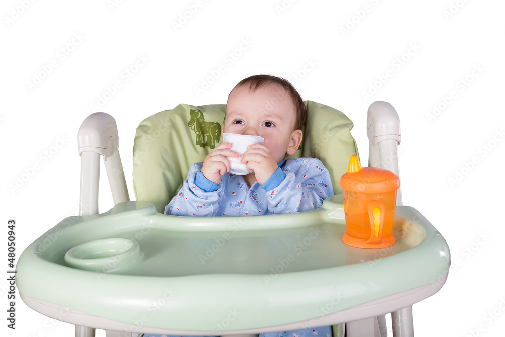 child is eating sitting at table, isolated over white child is eating sitting at table, isolated over white