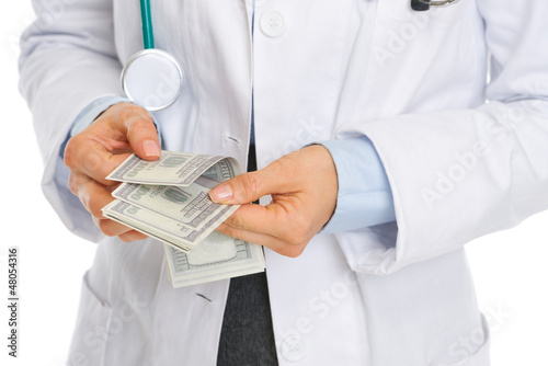 Closeup on medical doctor counting dollars