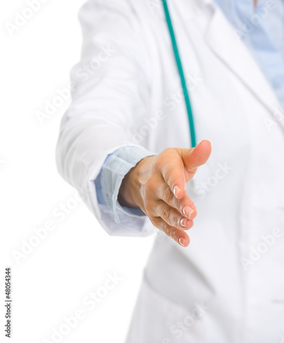 Closeup on medical doctor woman stretching hand for handshake
