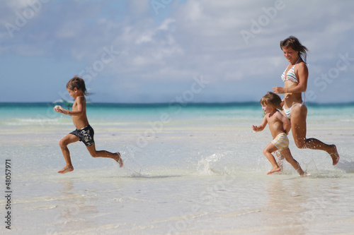 young happy family - mother and children - having fun on tropic