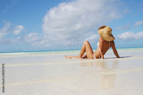 young smiling woman in summer hat on tropical sea background
