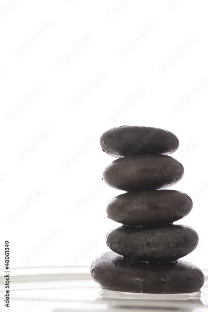 Green leaves over zen stones pyramid on water surface Green leaves over zen stones pyramid on water surface