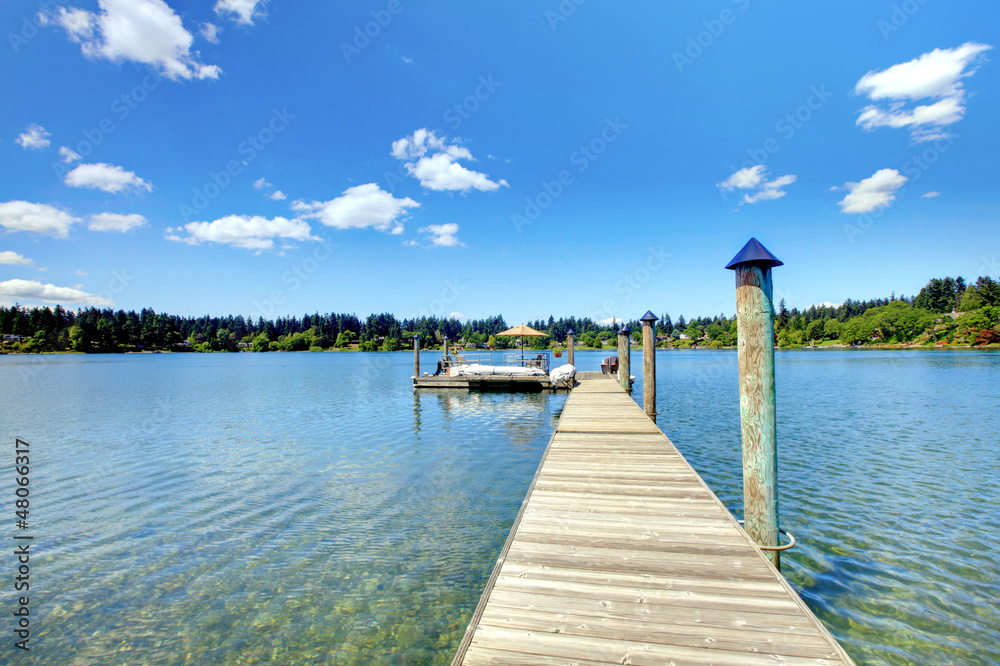 Lake with long wood pier and private party raft.