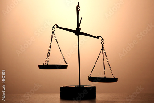 Gold scales of justice on brown background photo