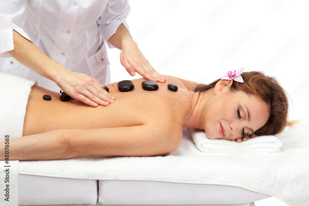Obraz premium beautiful woman in spa salon with spa stones getting massage,