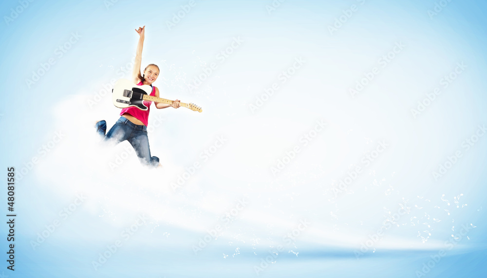 young woman playing on electro guitar and jumping