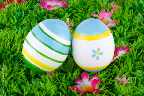 bemalte bunte Eier für Ostern auf Wiese mit Blüten