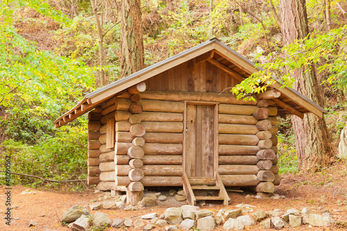 Old solid log cabin shelter hidden in the forest