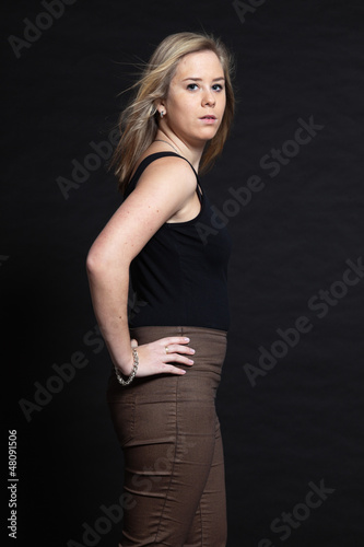 Pretty blonde girl against dark background. Studio shot.