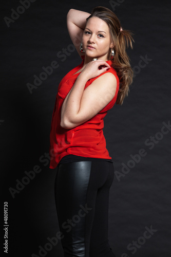 Pretty brunette girl against dark background. Studio shot.