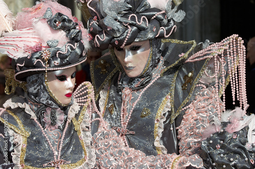 Person in Venetian costume attends Carnival of Venice.