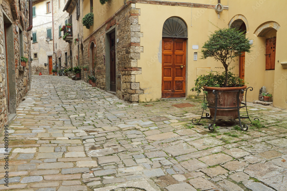 narrow italian street and small patio in tuscan village