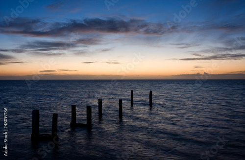 Poles in see at sunrise © Matauw