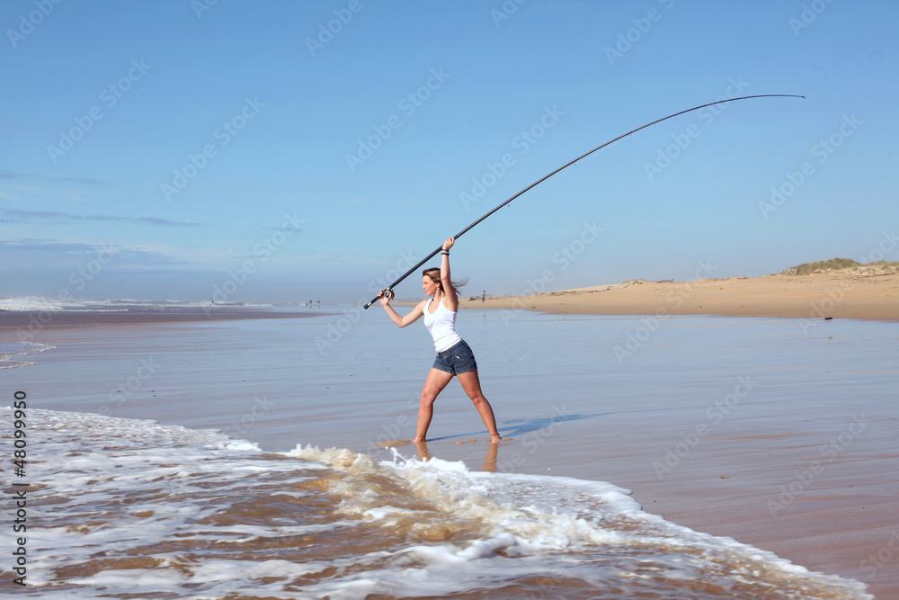 Beach lady casting fishing rod Stock Photo
