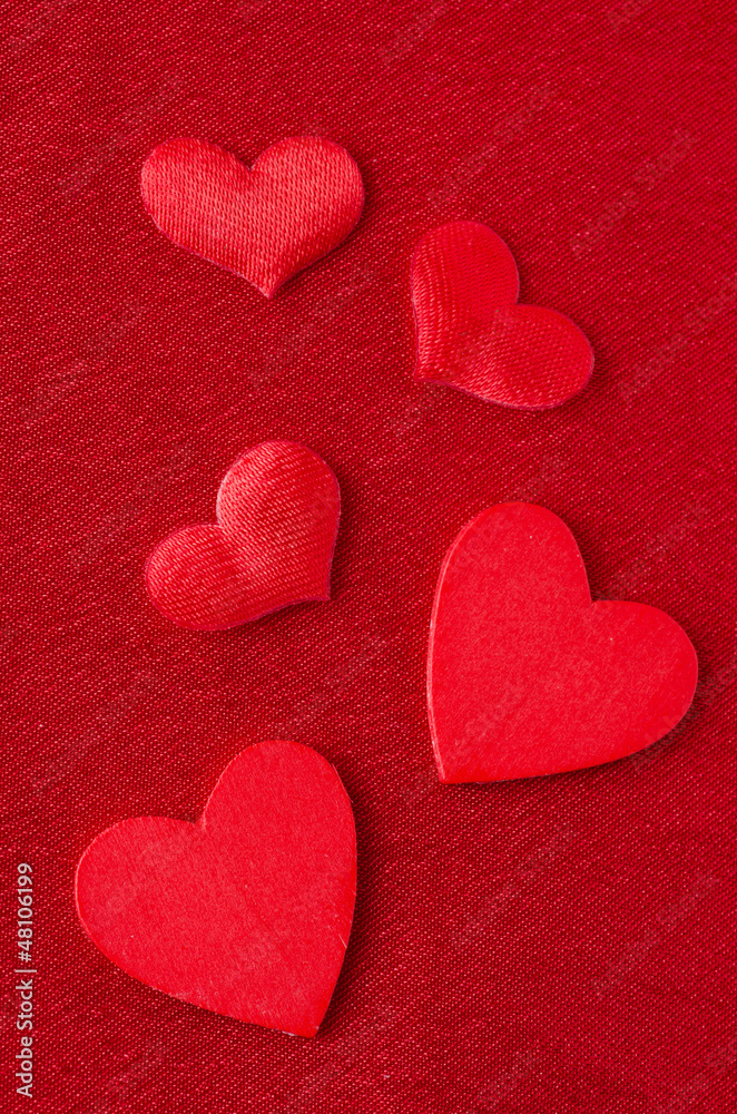 Hearts of different sizes on a red background