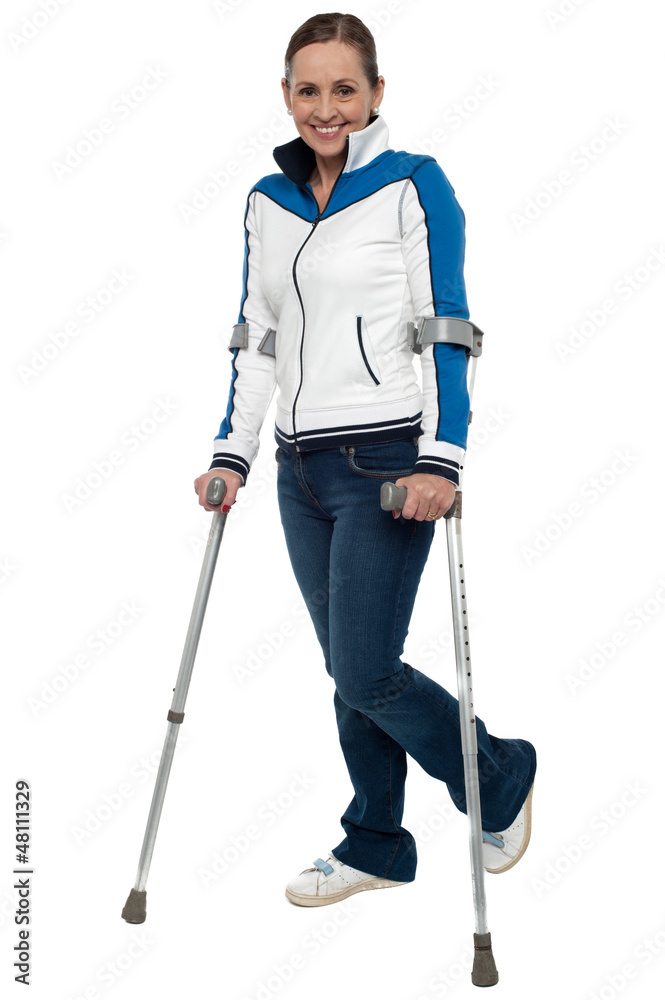 Woman walking with the support of crutches Woman walking with the support of crutches