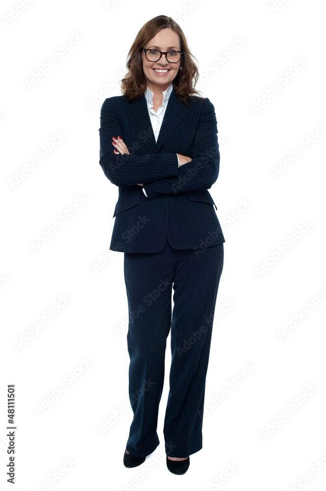 Executive in business attire standing arms folded Executive in business attire standing arms folded