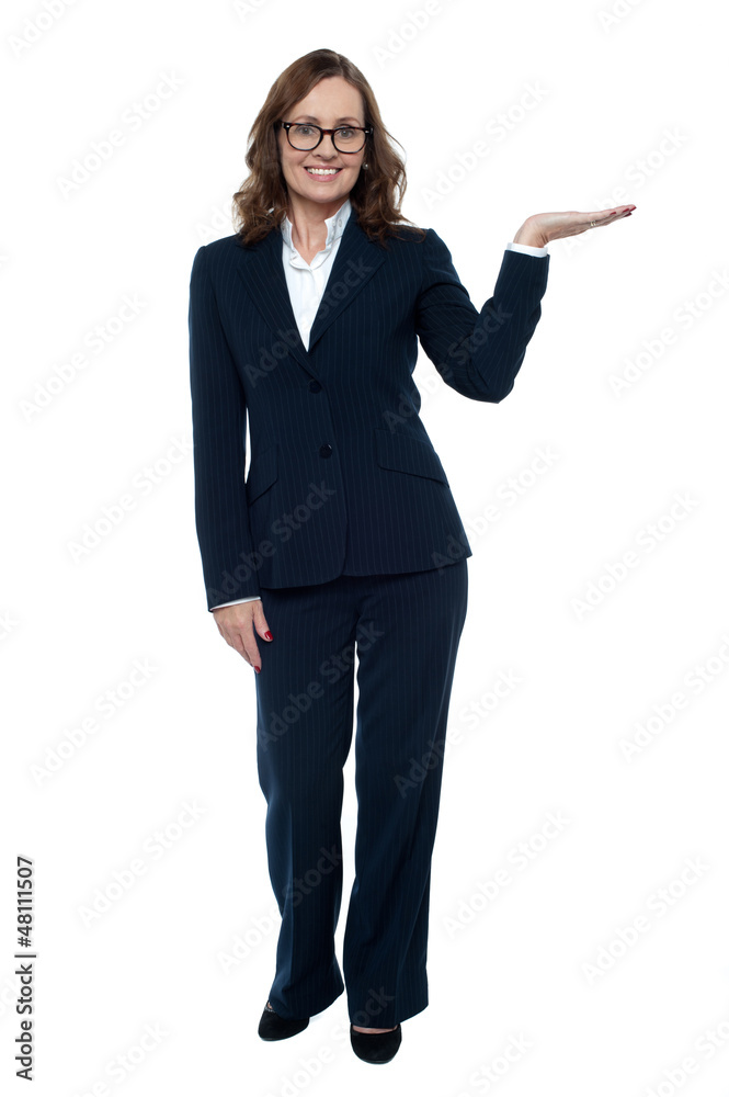 Woman in business attire posing with an open palm Woman in business attire posing with an open palm