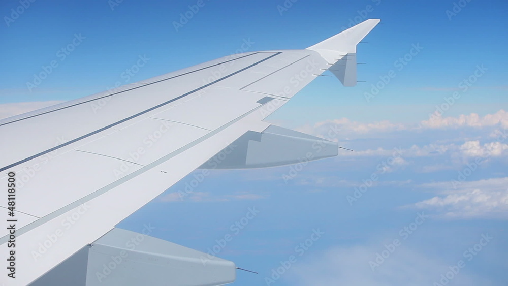 Wing of airplane and blue sky with clouds Wing of airplane and blue sky with clouds