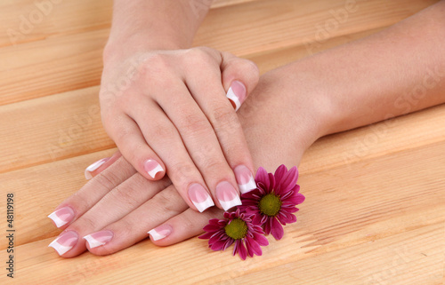 Fototapeta Naklejka Na Ścianę i Meble -  Woman hands with french manicure and flowers
