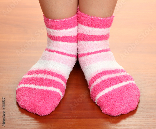 Legs female in striped socks on laminate floor
