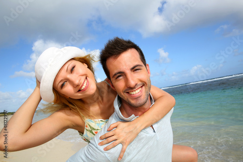 Cheerful couple enjoying vacation at the beach © goodluz