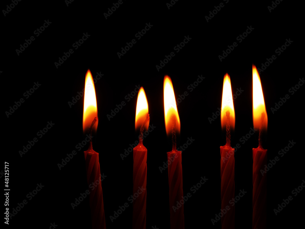 Five red candles burning in the dark - black background Five red candles burning in the dark - black background
