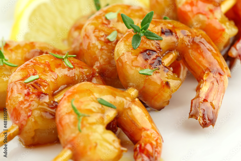Glazed shrimp skewers with thyme and lemon closeup Glazed shrimp skewers with thyme and lemon closeup