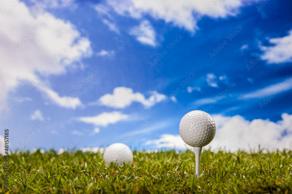 Golf balls, green grass, clouds background Golf balls, green grass, clouds background