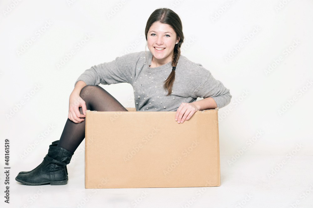 junges Mädchen sitzt in einem Karton junges Mädchen sitzt in einem Karton