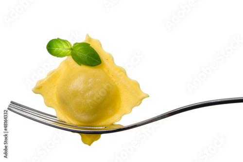 ravioli pasta parcel and basil garnish on fork white background photo