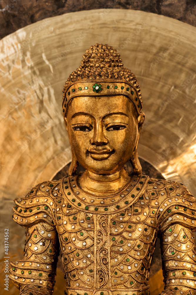 Goldener Buddha auf goldenem Kissen vor goldenem Gong