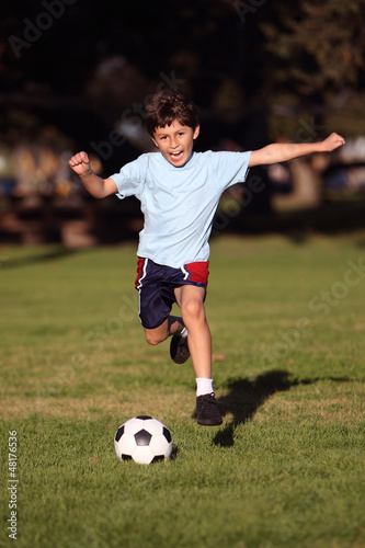 Boy playing soccer in the park © Nicholas B