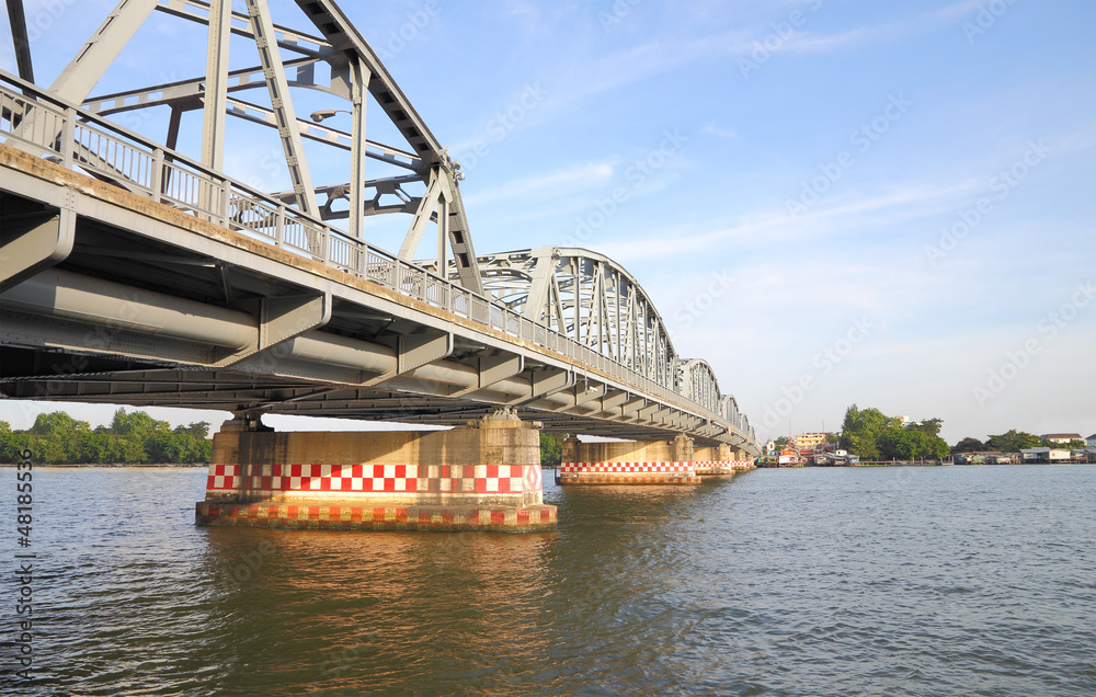 Obraz premium Metal bridge across local river to country.