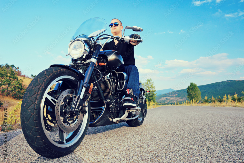Young biker posing on a customized motorcycle Young biker posing on a customized motorcycle