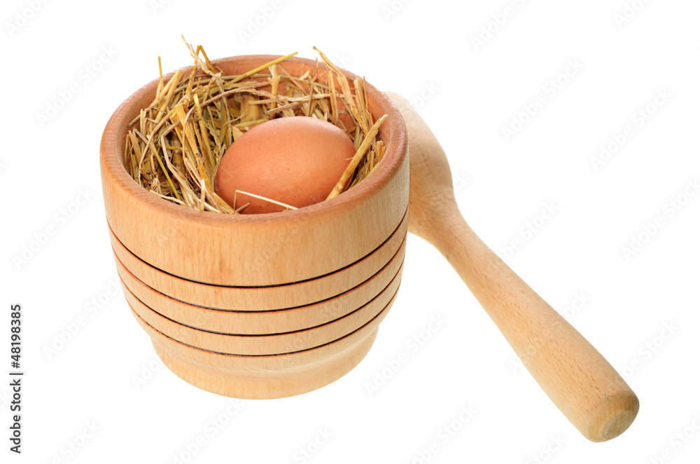 Fototapeta premium mortar with egg placed in straw isolated on white background