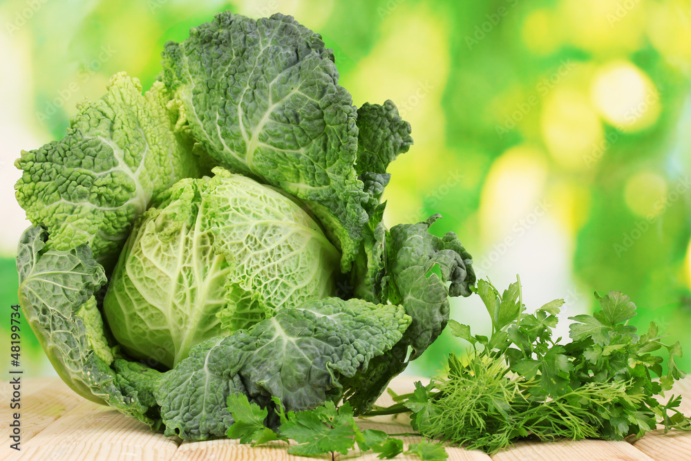 Fresh savoy cabbage on wooden table on natural background Fresh savoy cabbage on wooden table on natural background