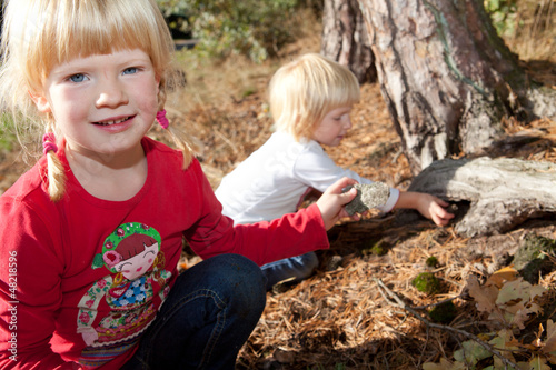 Zwei Kinder spielen Schnitzeljagd im Wald