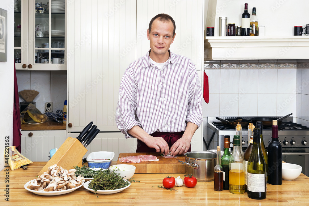 Man Preparing Meat At Kitchen Counter Man Preparing Meat At Kitchen Counter