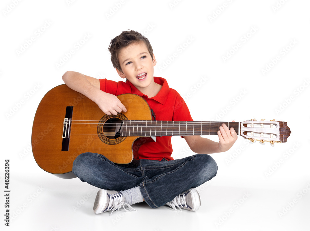 Smiling boy is playing the acoustic guitar Smiling boy is playing the acoustic guitar