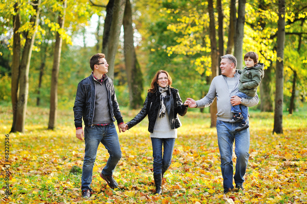Obraz premium Happy family walking together in a park
