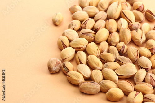 tasty pistachio nuts, on beige background