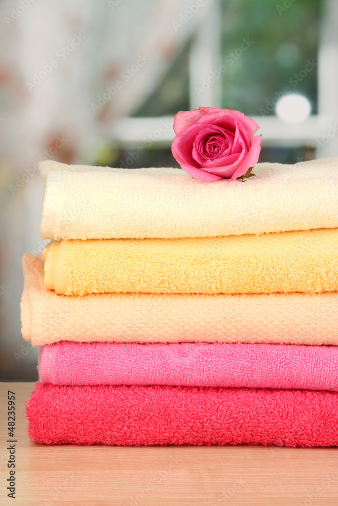 Stack of towels with fragrant flower on window background Stack of towels with fragrant flower on window background