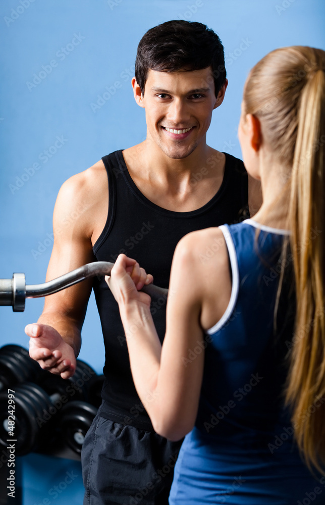 Personal trainer shows woman the correct exercise Personal trainer shows woman the correct exercise