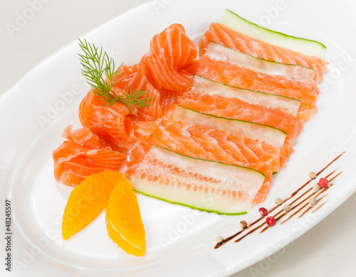 Fresh salmon with orange and cucumber on white background